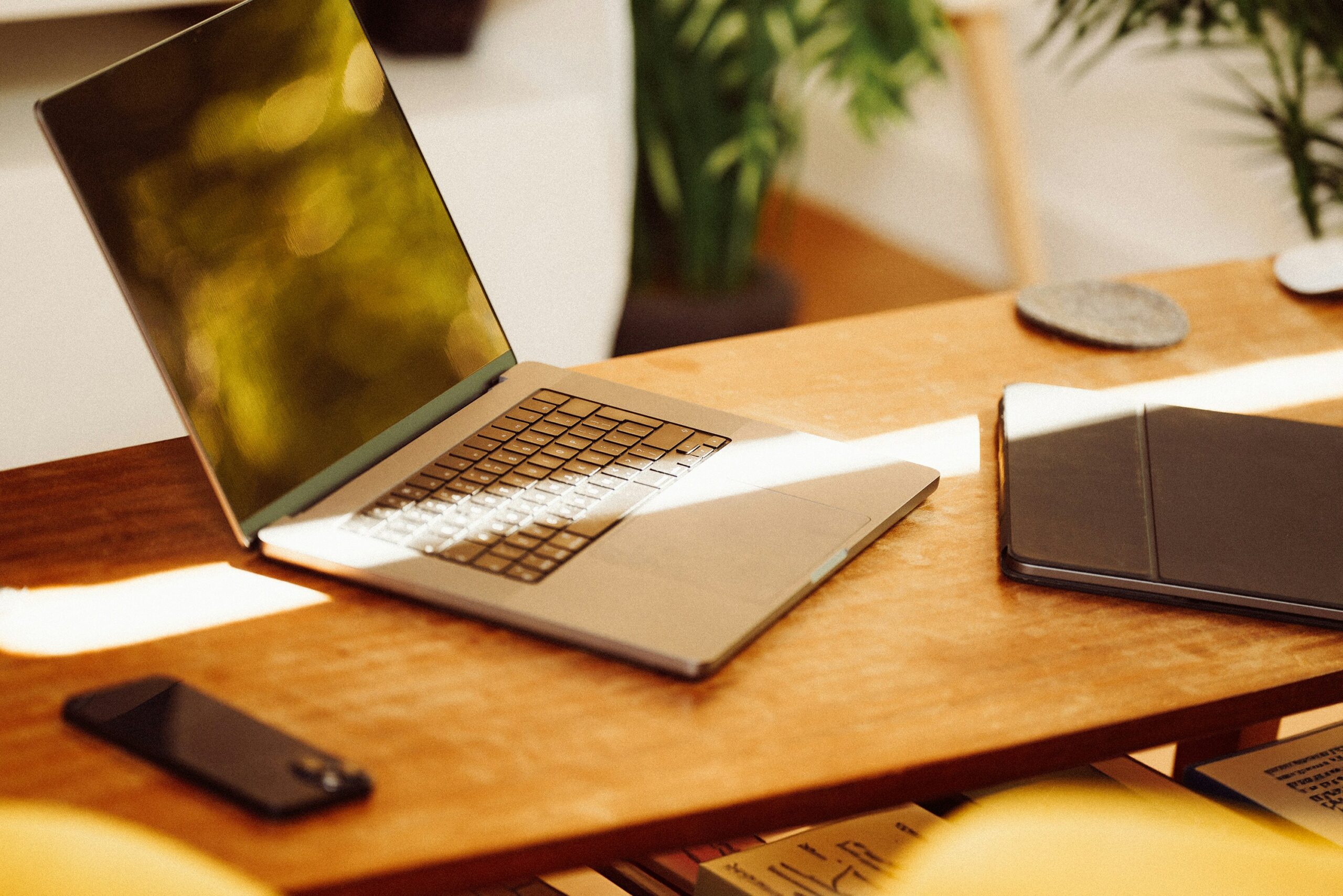 A Mac Computer, an Iphone, and tablet on a table