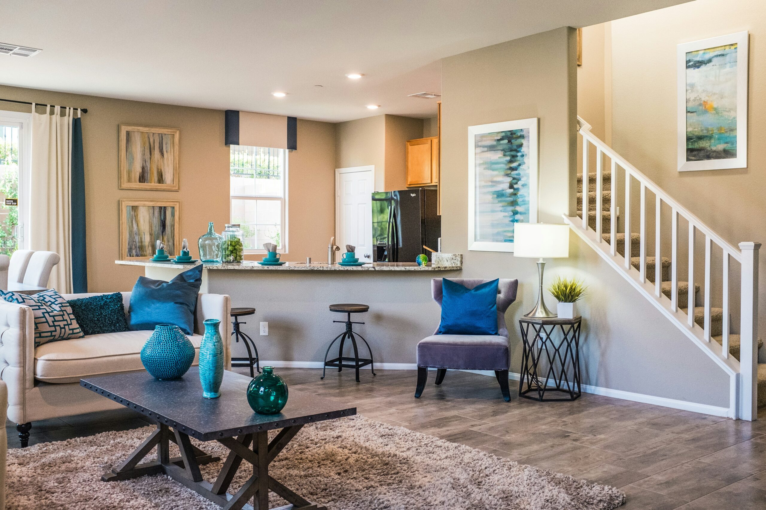 Clean Living room set up with blue decor points and a staircase on the side